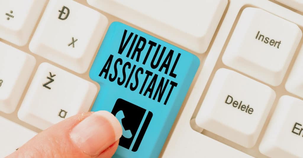 Finger pressing blue Virtual Assistant key on an Iligan City-themed computer keyboard.