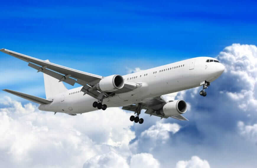 White passenger airplane soaring above white clouds with a clear blue sky backdrop, reminiscent of Iligan flights.