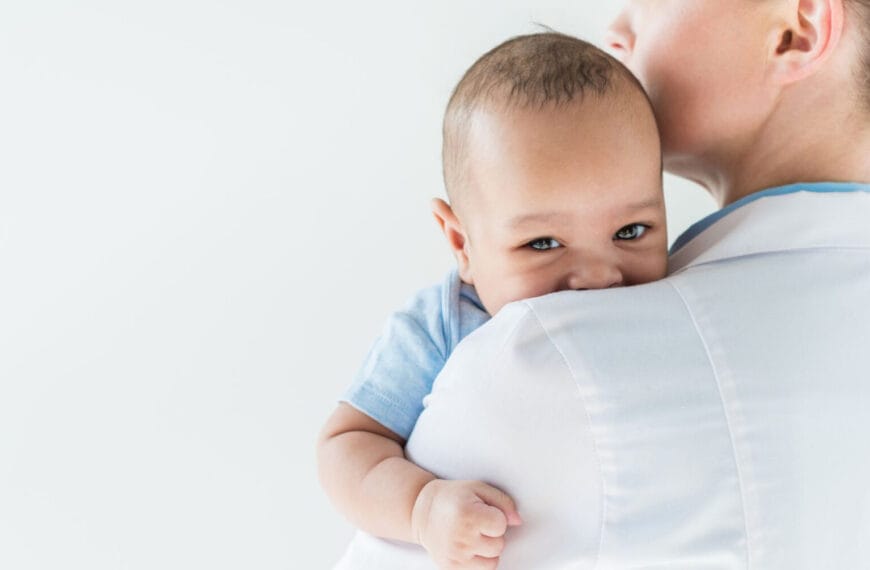 Adult holding a baby against their shoulder, baby looking at the camera, reminiscent of a serene moment in Pedia Iligan.