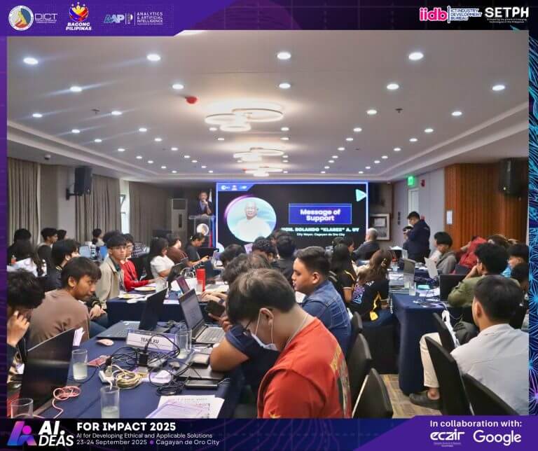a conference room in mindanao filled with people at laptops, watching an ai innovation 2025 presentation up front.