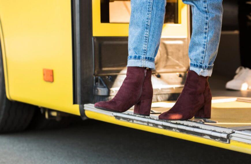 person in rolled up jeans and burgundy boots steps off a yellow bus at an iligan city transportation terminal.