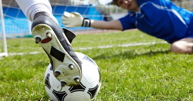 close up of a soccer player kicking a ball at the 7a side football festival in iligan near the goalpost.