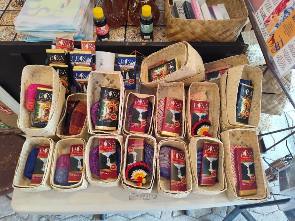 wicker baskets on a table display iligan arts crafts and souvenirs in small woven fabrics and colorful red boxes.