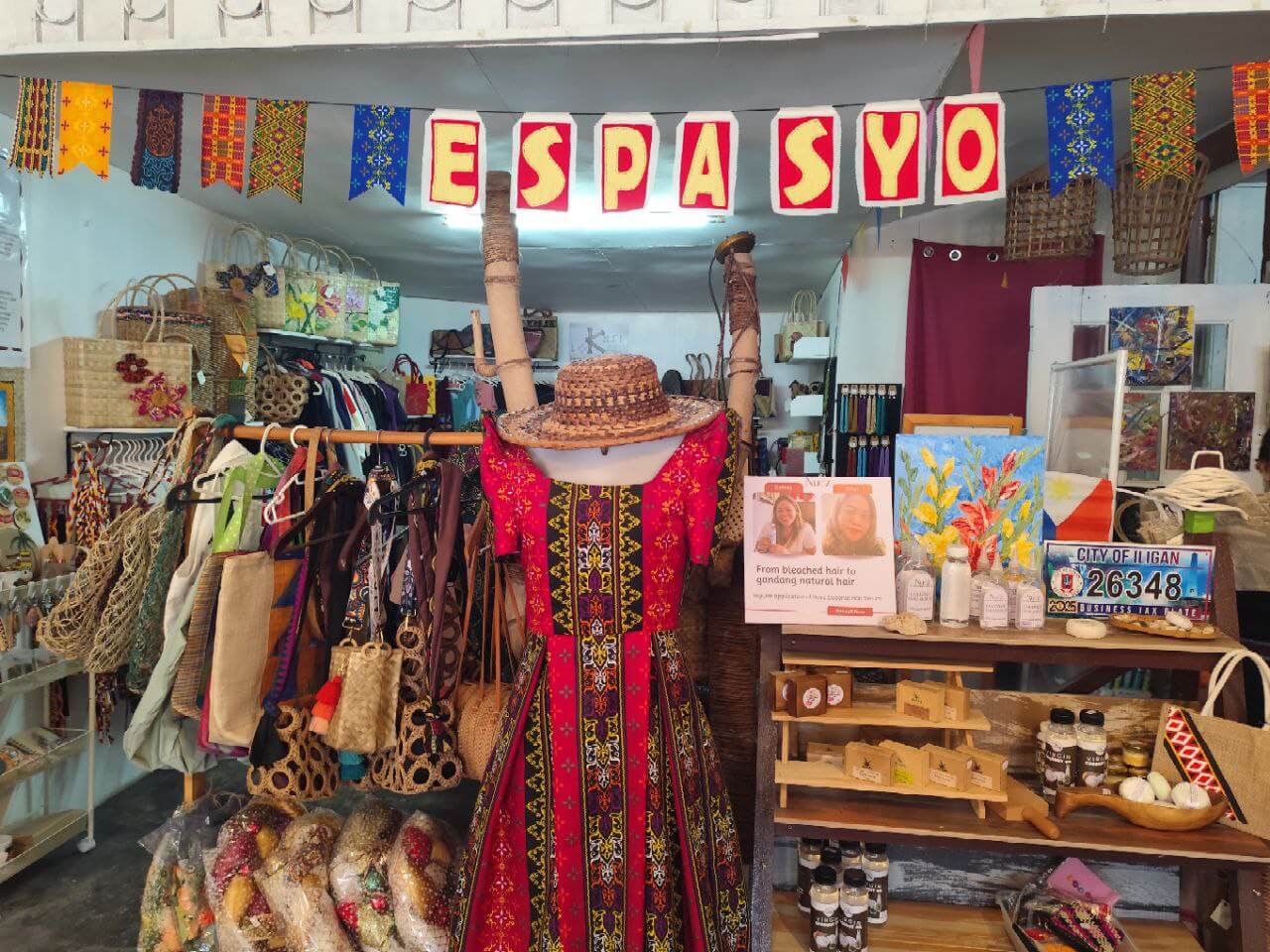 colorful shop with traditional filipino dress, iligan arts crafts, bags, hats, paintings, and a sign reading espasyo.