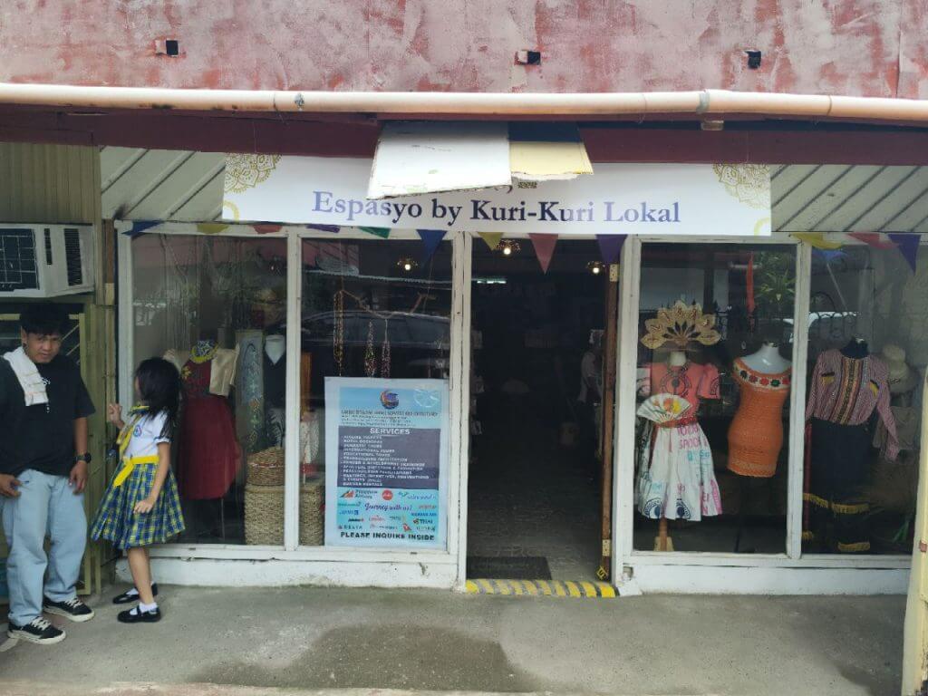 a storefront labeled espasyo by kuri kuri lokal displays iligan arts, traditional clothing, and handmade crafts.
