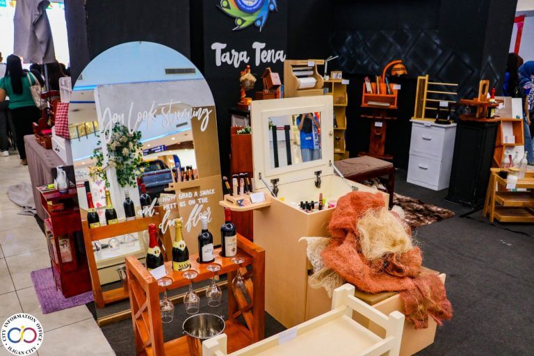 a display of wine bottles, mirrors, and wooden furniture at an indoor exhibition booth.