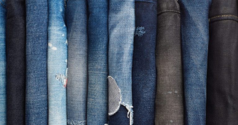 folded blue and black jeans, some distressed, neatly arranged—perfect for a thrift hunt iligan adventure.