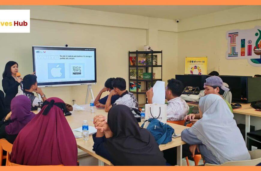 a woman presents to a group in a classroom with a screen showing apple and nestlé logos.