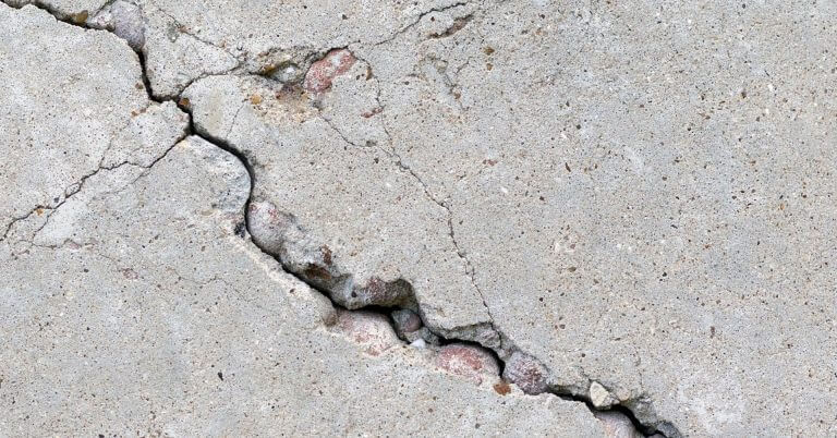 close up of cracked, rough concrete surface in iligan city, showing fissures and reddish stones—earthquake safety.