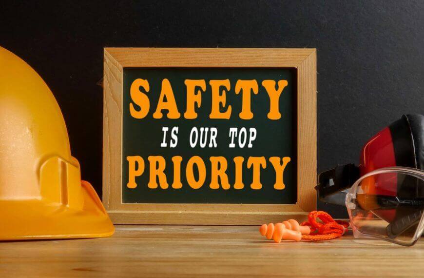 yellow hard hat, goggles, and earplugs by a sign reading safety is our top priority for iligan engineers.