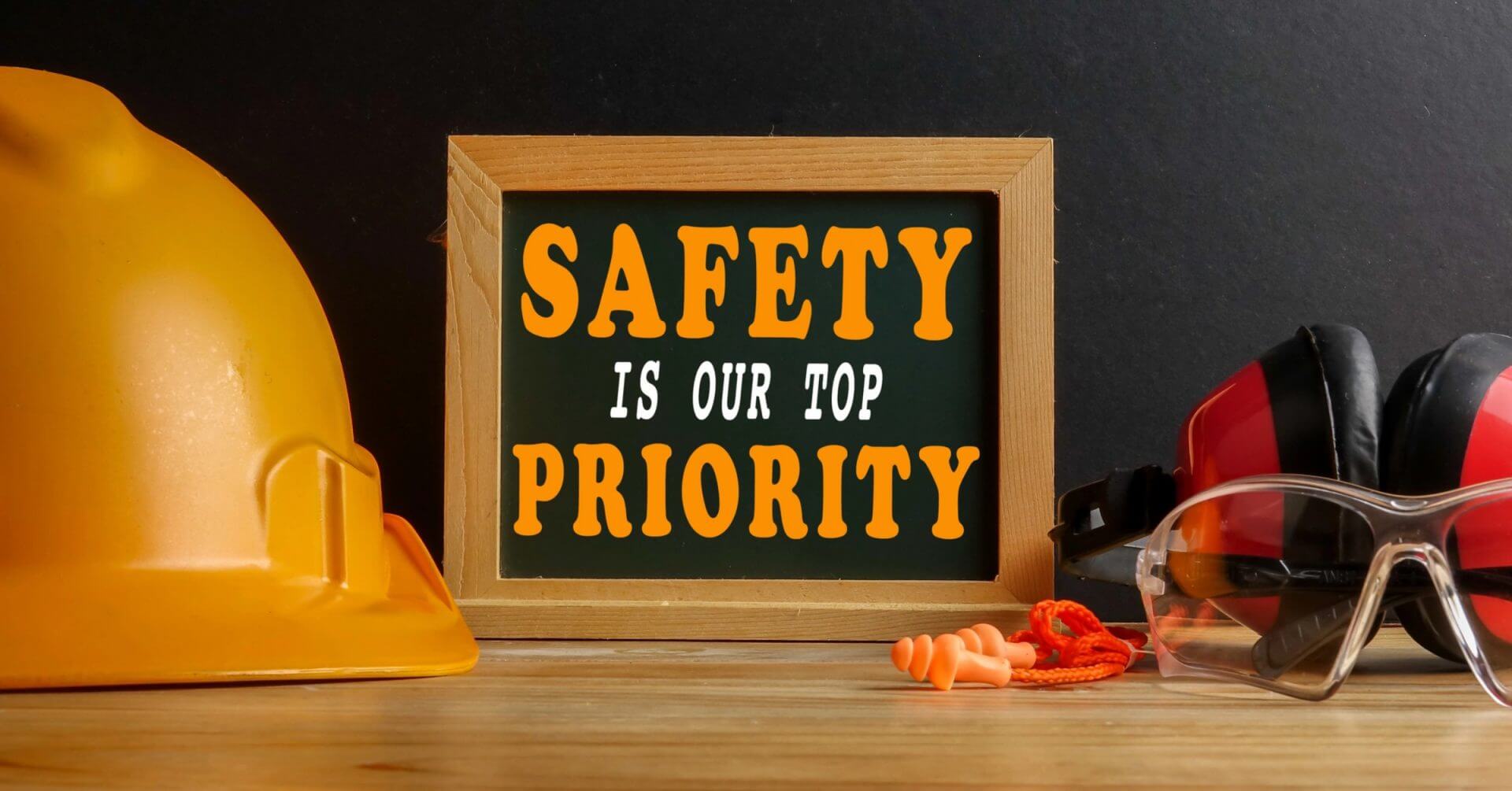 yellow hard hat, goggles, and earplugs by a sign reading safety is our top priority for iligan engineers.