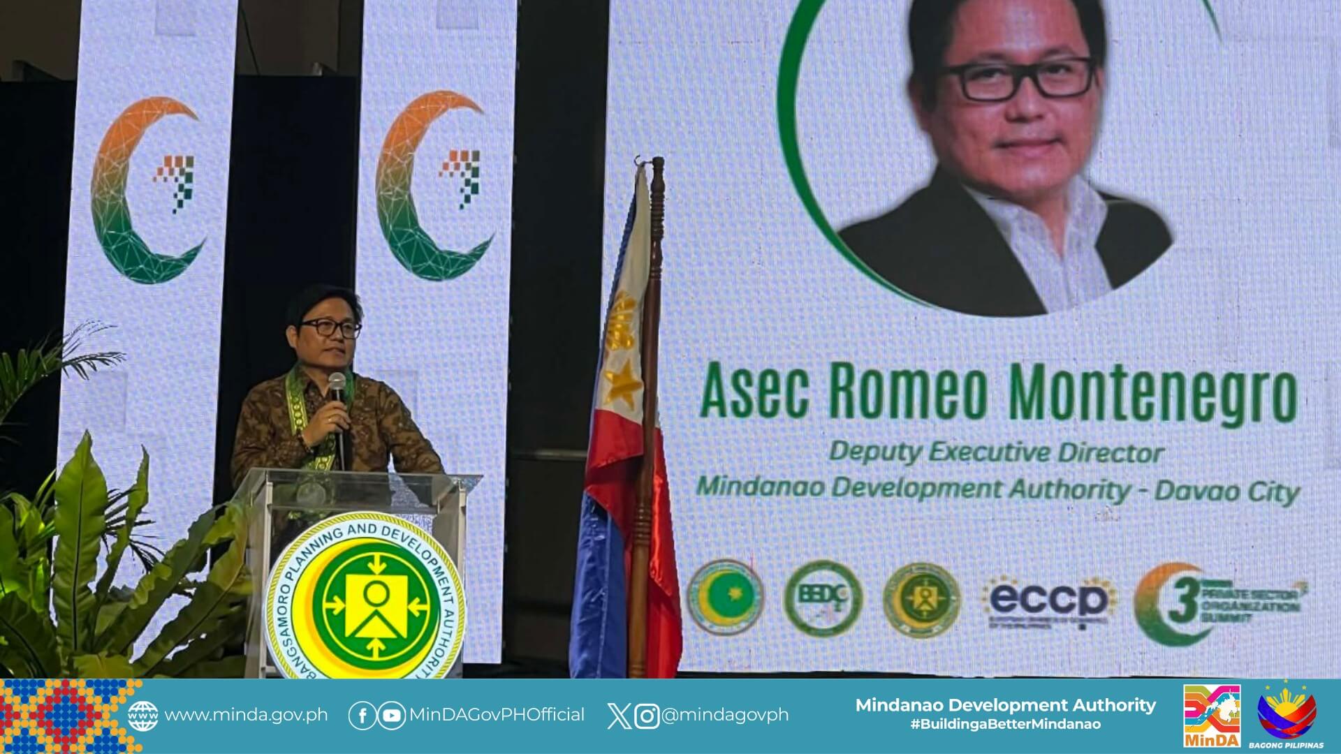 a man speaks at a podium beside a display on asec romeo montenegro’s role in barmm’s inclusive growth.