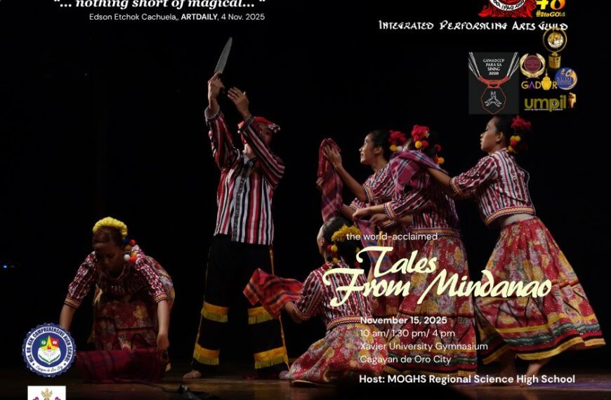 five dancers in colorful costumes perform with bamboo poles on a dark stage, mid movement, hands raised.