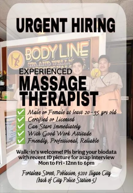 two smiling massage therapists stand in front of a body line spa sign, holding a “urgent hiring” notice.