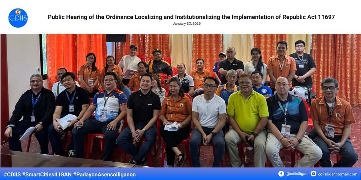 a group poses indoors at an iligan city public hearing on the ev ordinance, smiling and seated in rows.