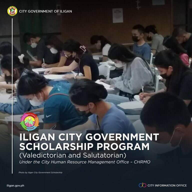 top students wearing masks sit at desks, writing, during the city scholarship program exam in iligan.